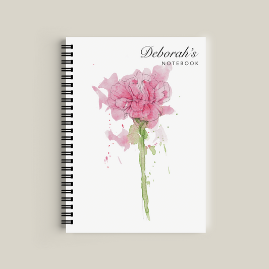 Notebook with pink floral design and 'Deborah's Notebook' text on a beige background