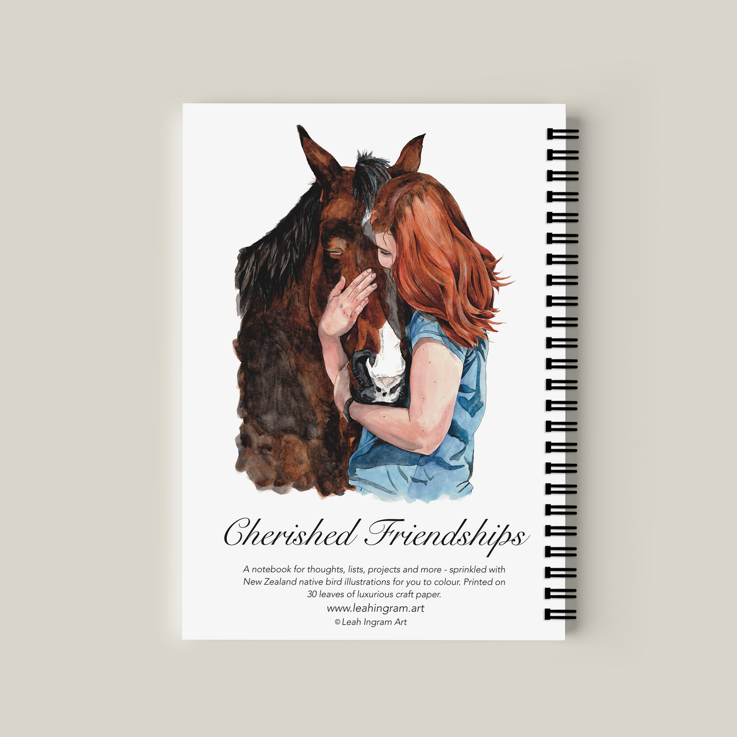 Notebook with illustration of a woman and horse on the cover, on a beige background