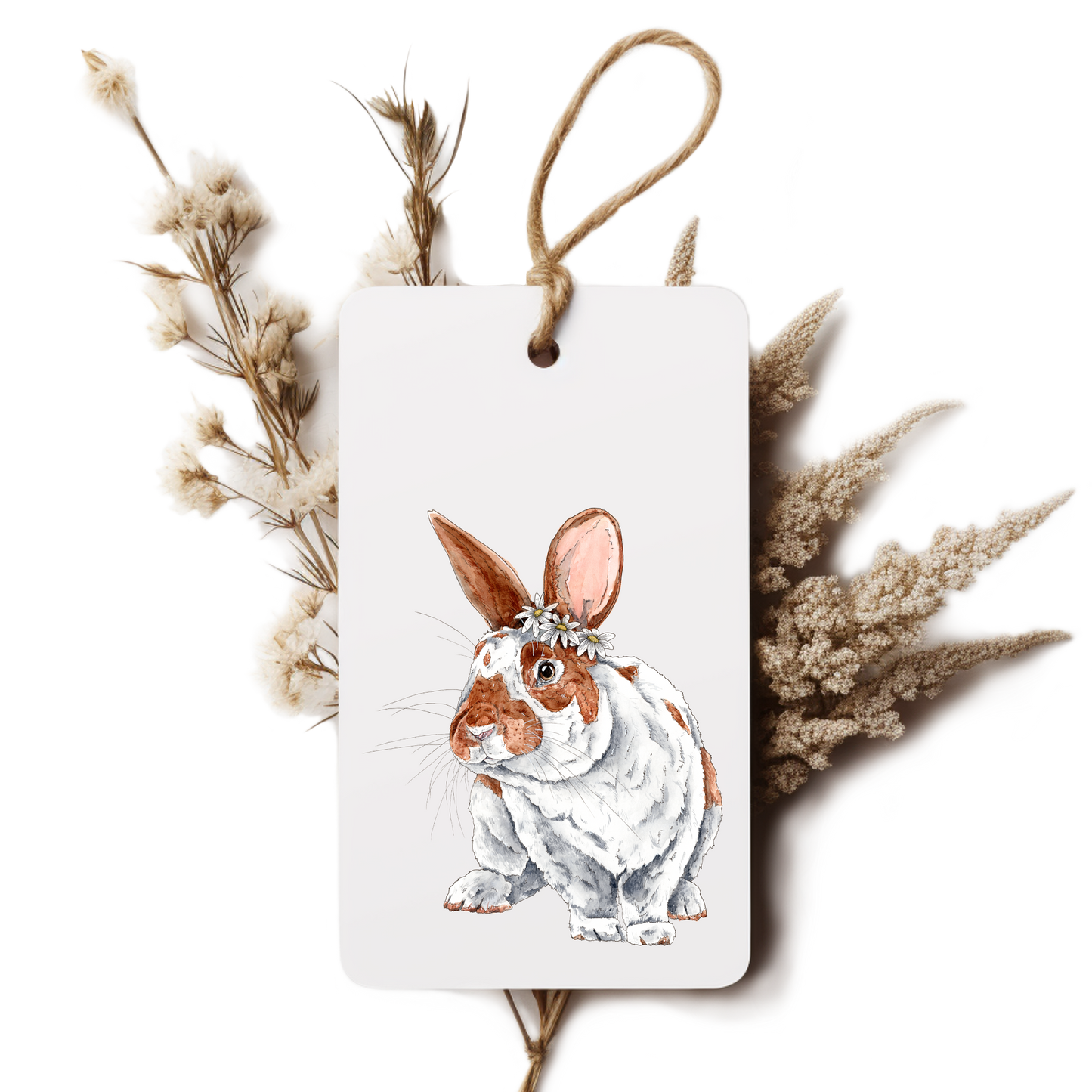 Decorative tag with a rabbit illustration surrounded by dried plants on a white background