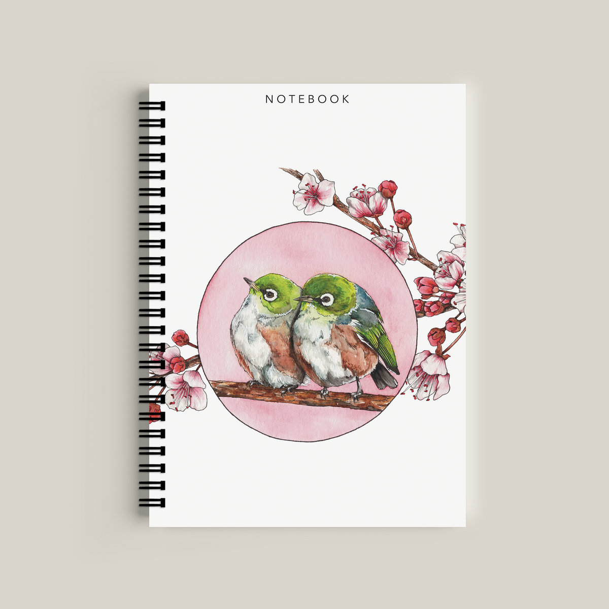 Notebook with a design of two birds and cherry blossoms on a pink background