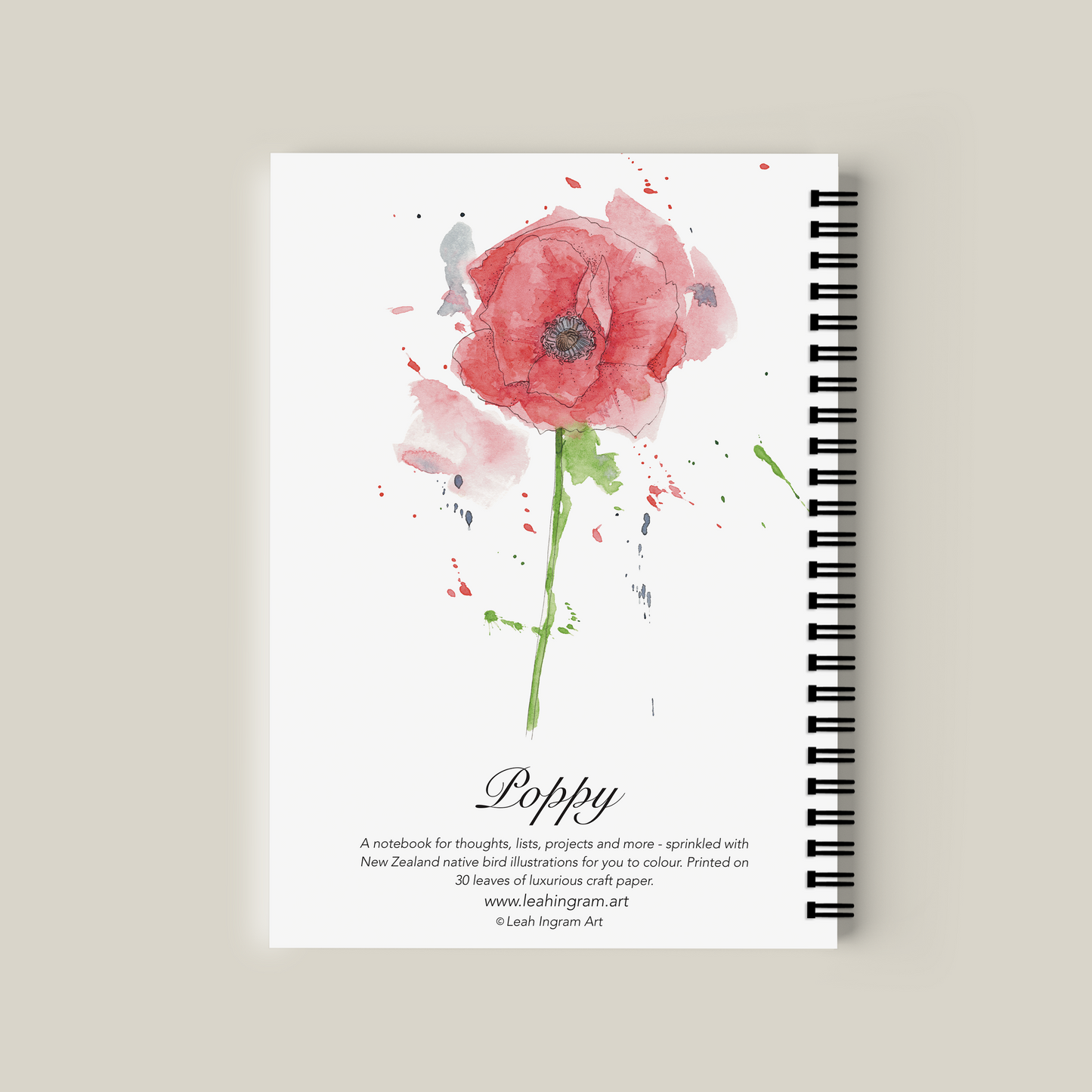 Notebook with watercolor poppy design on the cover against a beige background