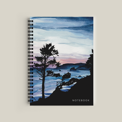 Notebook with a scenic cover featuring trees and water on a beige background