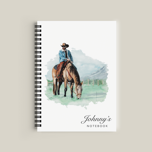 Notebook with a cover illustration of a person on a horse and the text 'Johnny's Notebook' on a beige background.