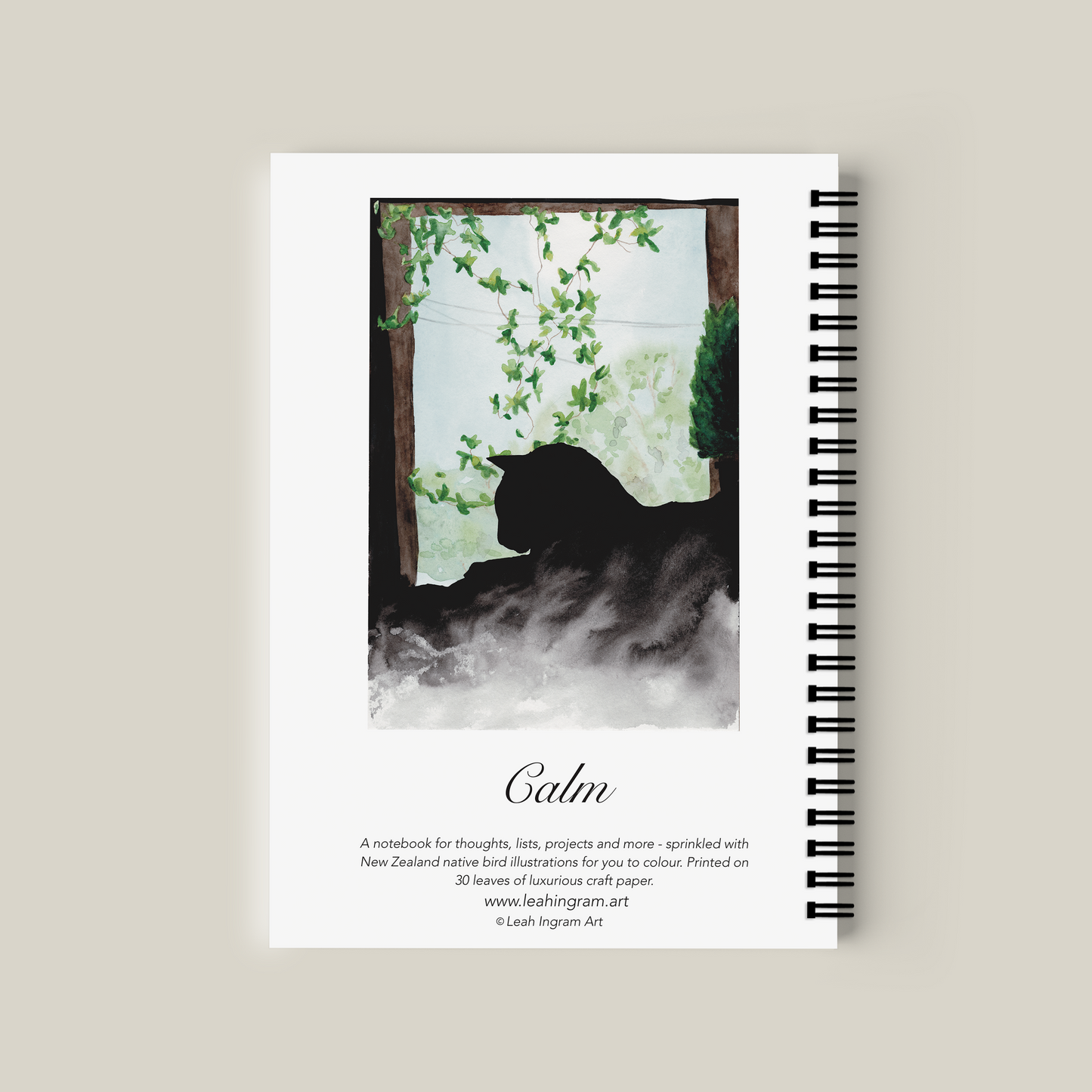 Notebook with a cat silhouette and nature design on the cover, on a beige background