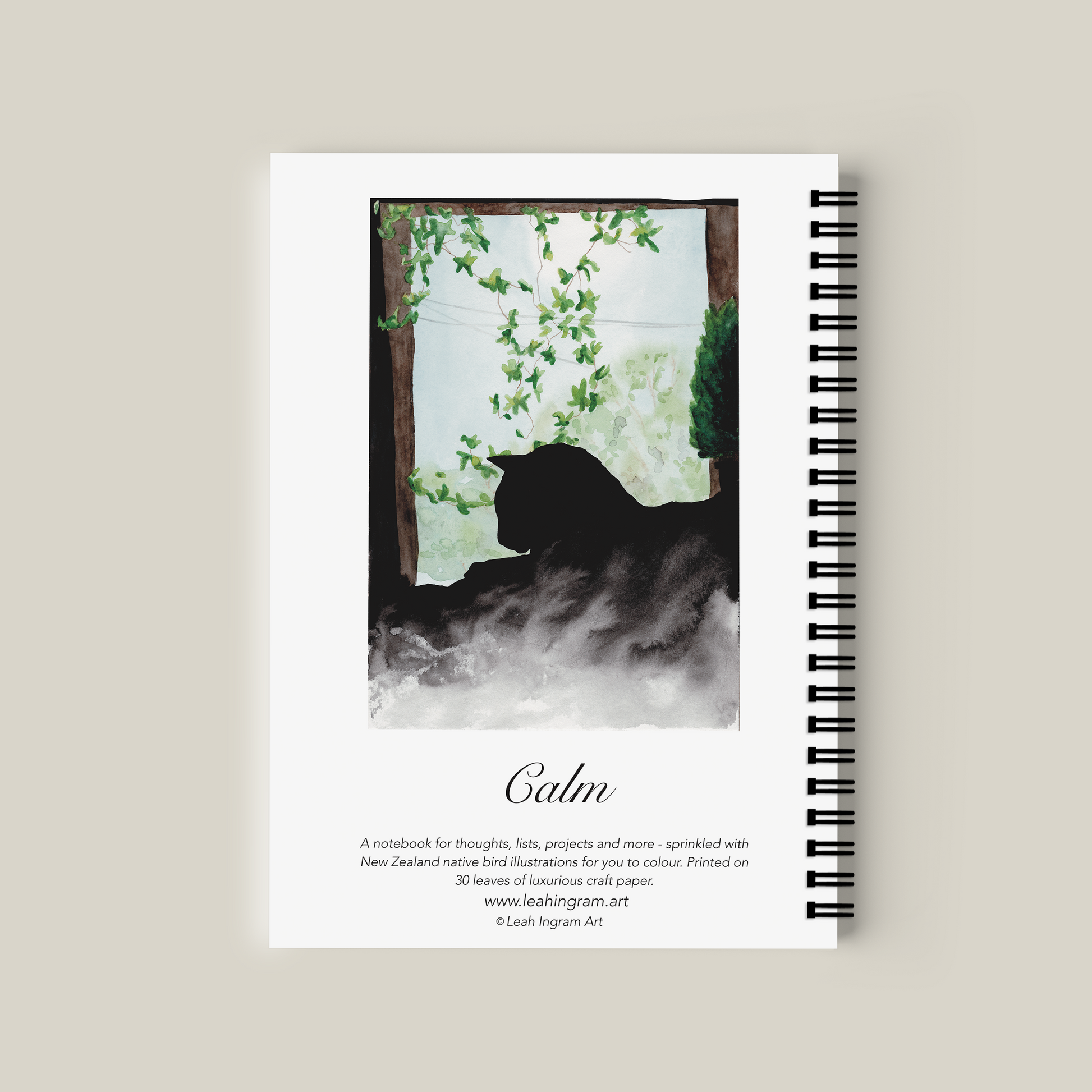 Notebook with a cat silhouette and nature design on the cover, on a beige background