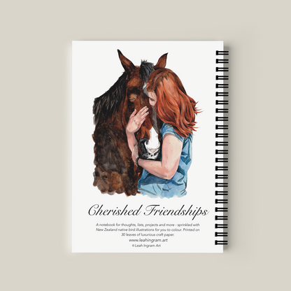 Notebook with illustration of a woman and horse on the cover, on a beige background