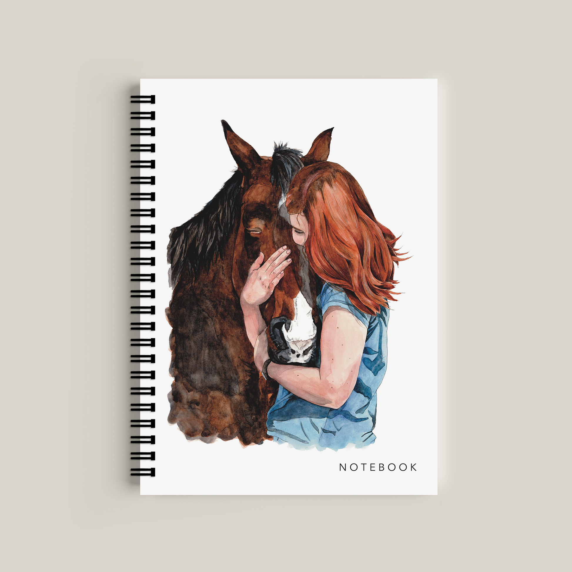 Notebook with a cover illustration of a woman hugging a horse on a beige background