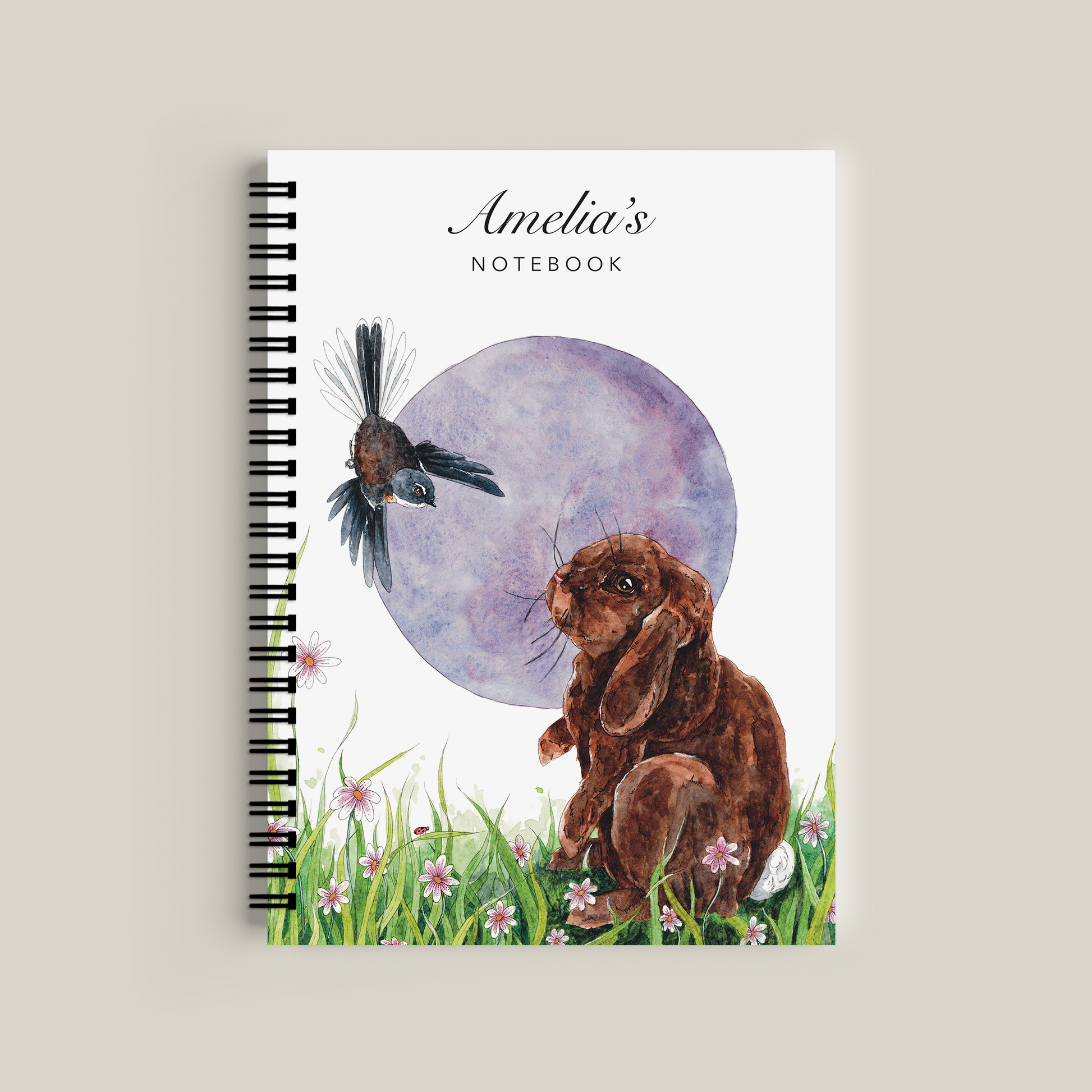 Notebook with a design of a dog and bird on the cover, on a light gray background