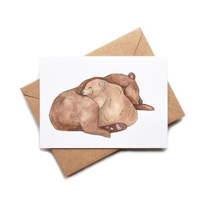 Greeting card with two bears embracing on a white background, accompanied by a brown envelope.