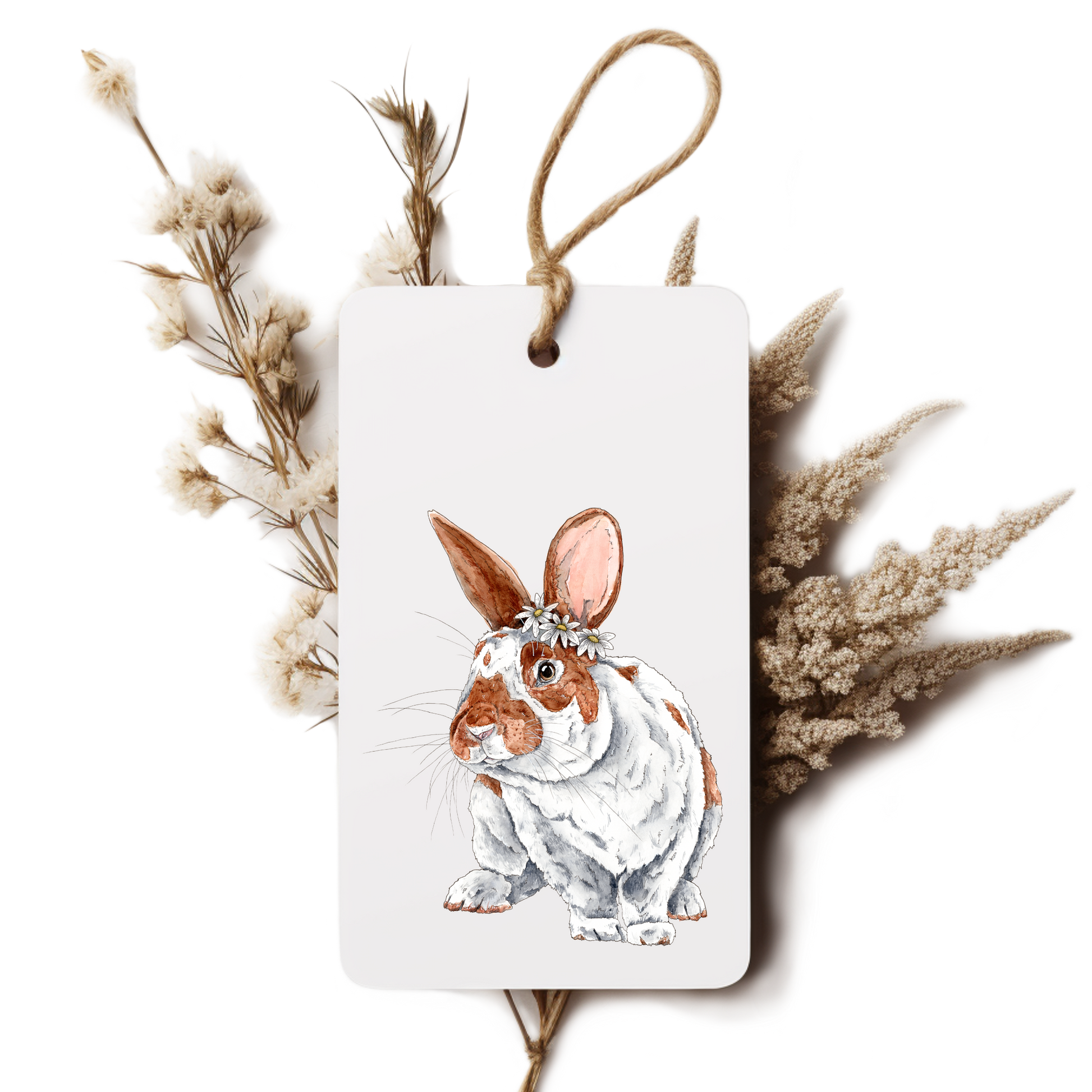 Decorative tag with a rabbit illustration surrounded by dried plants on a white background