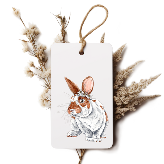 Decorative tag with a rabbit illustration surrounded by dried plants on a white background