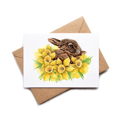 Card with a rabbit and daffodils on a white background