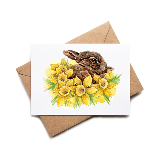 Card with a rabbit and daffodils on a white background