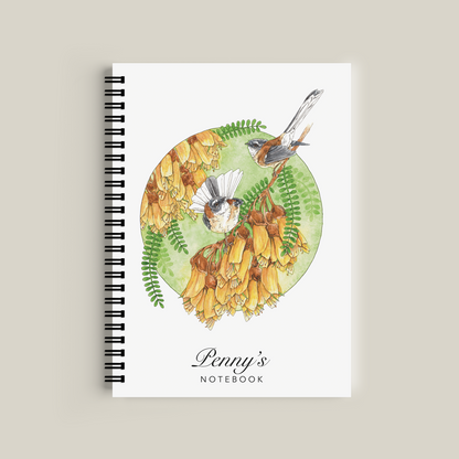 Notebook with nature-themed cover featuring birds and flowers on a beige background