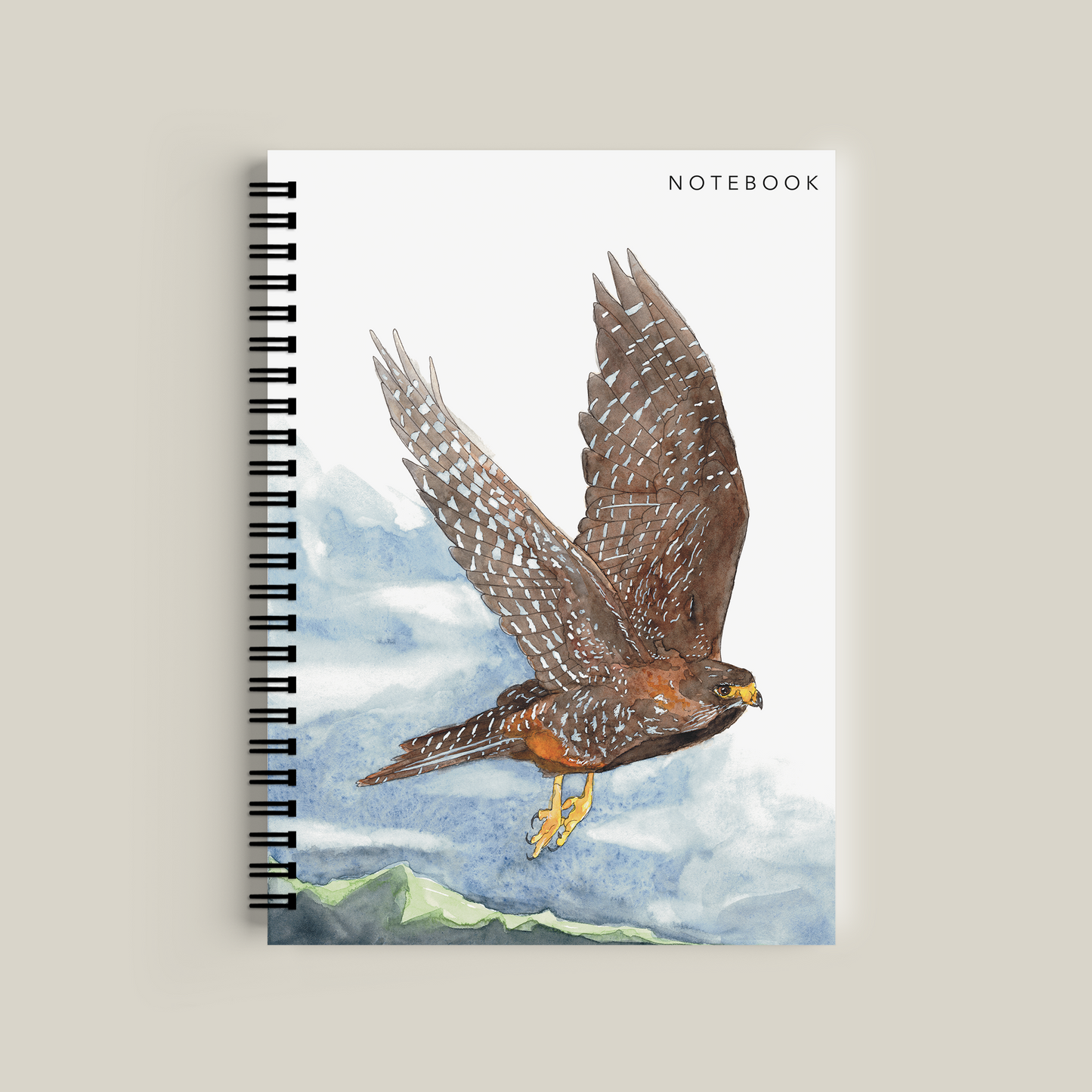 Notebook with a falcon illustration on a mountainous landscape cover