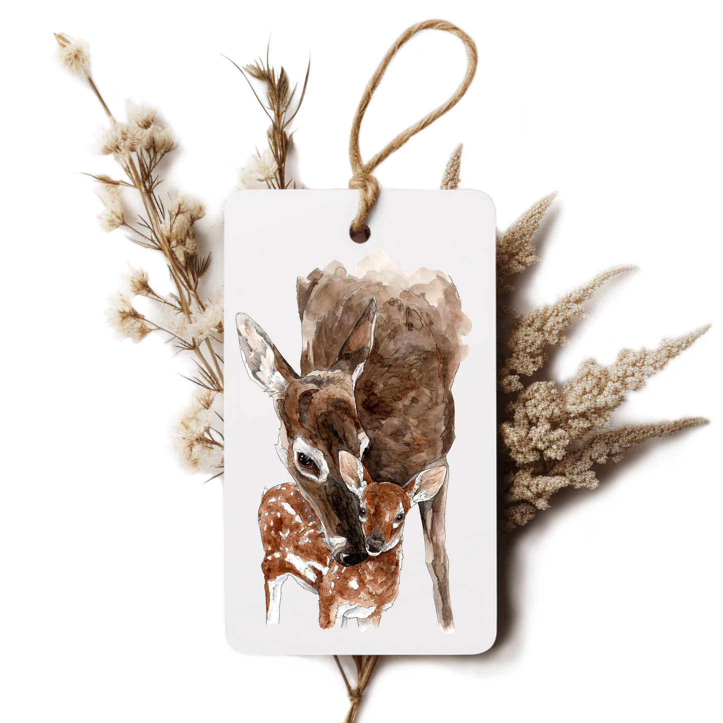 Decorative tag with a deer and fawn illustration surrounded by dried plants on a white background