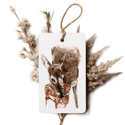 Decorative tag with a deer and fawn illustration surrounded by dried plants on a white background