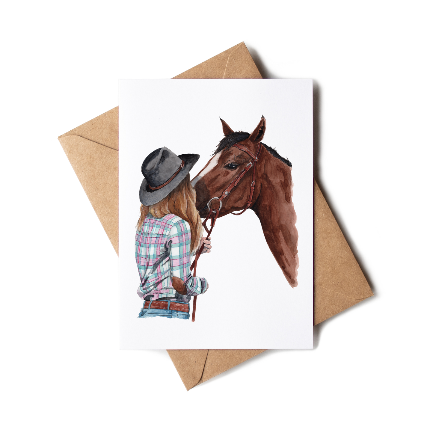 Greeting card with illustration of a person and horse, accompanied by a brown envelope on a white background.