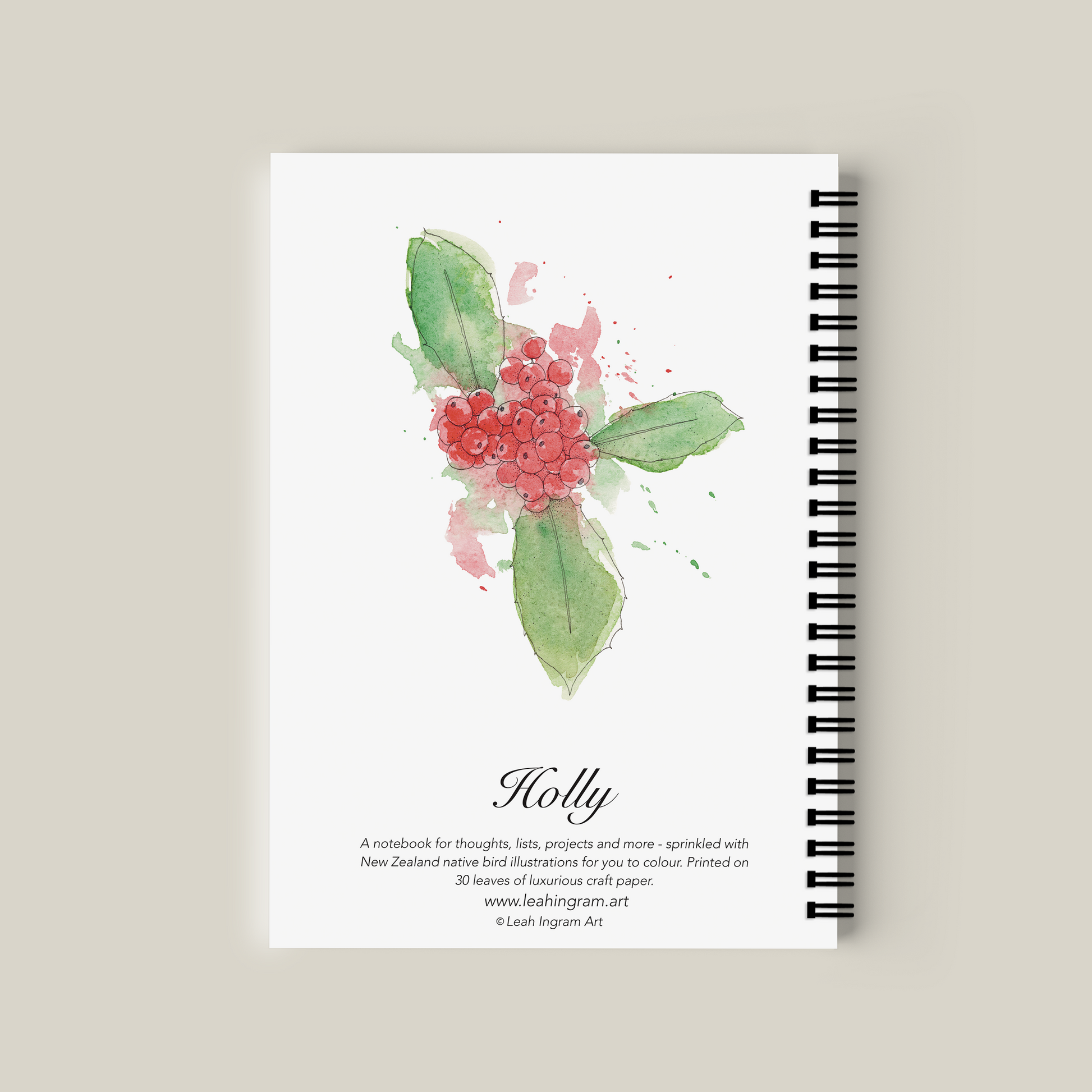 Notebook with holly design on cover against a beige background