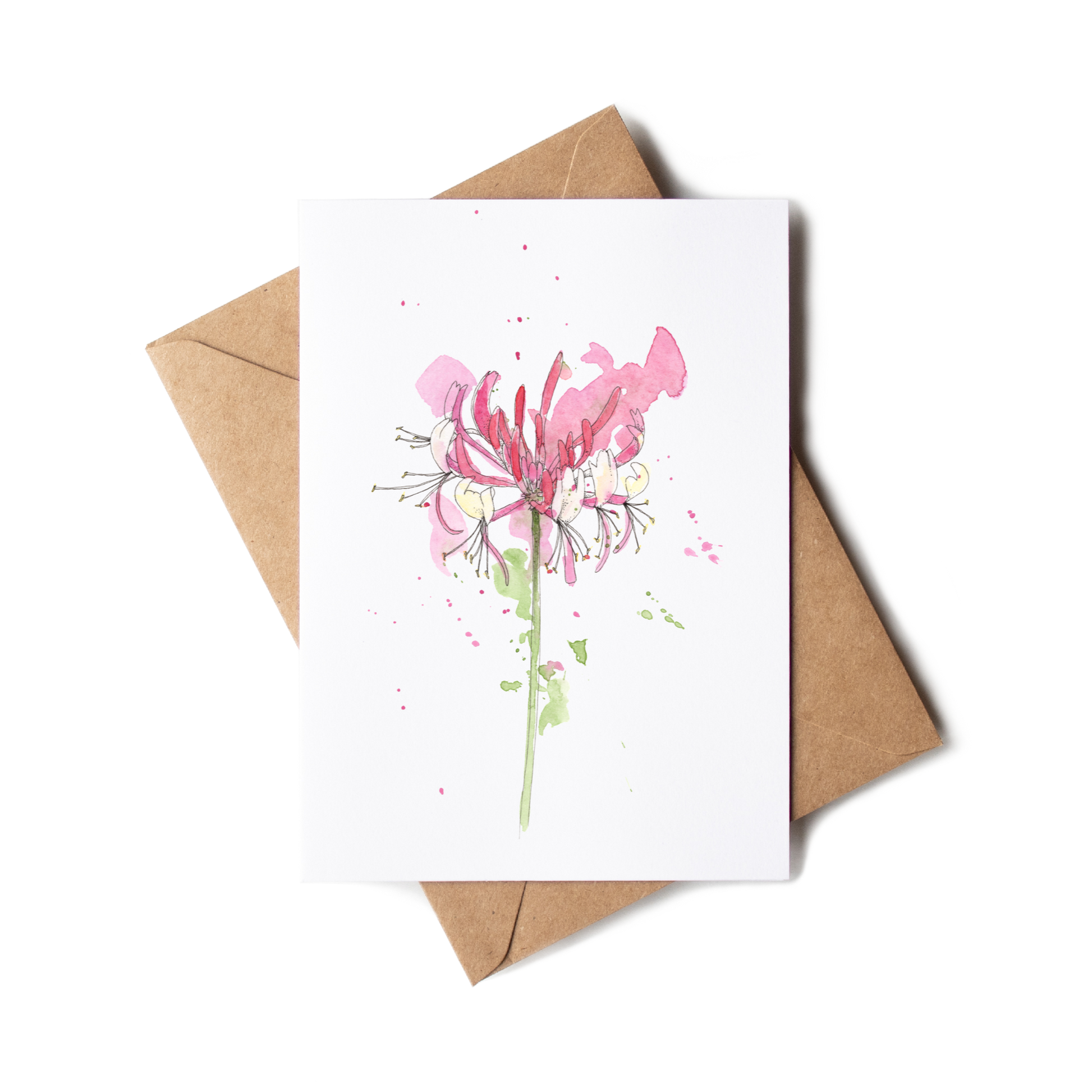 Greeting card with pink floral design and brown envelope on white background