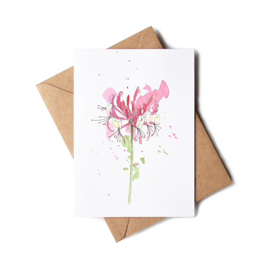 Greeting card with pink floral design and brown envelope on white background
