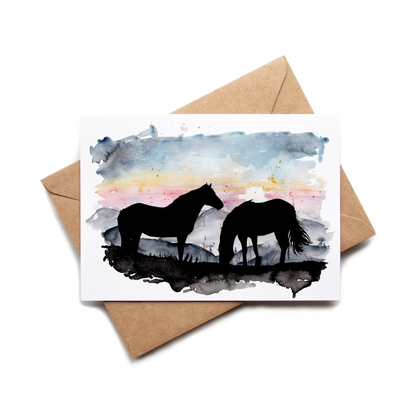 Card with horse silhouette design on a watercolor background, placed on a brown envelope.