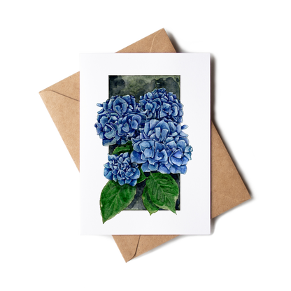 Greeting card with blue hydrangea flowers and a brown envelope on a white background