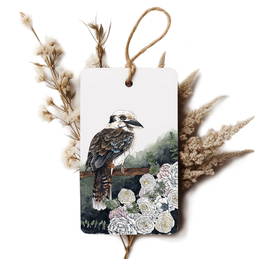 Decorative tag with a bird illustration surrounded by flowers and dried plants on a white background