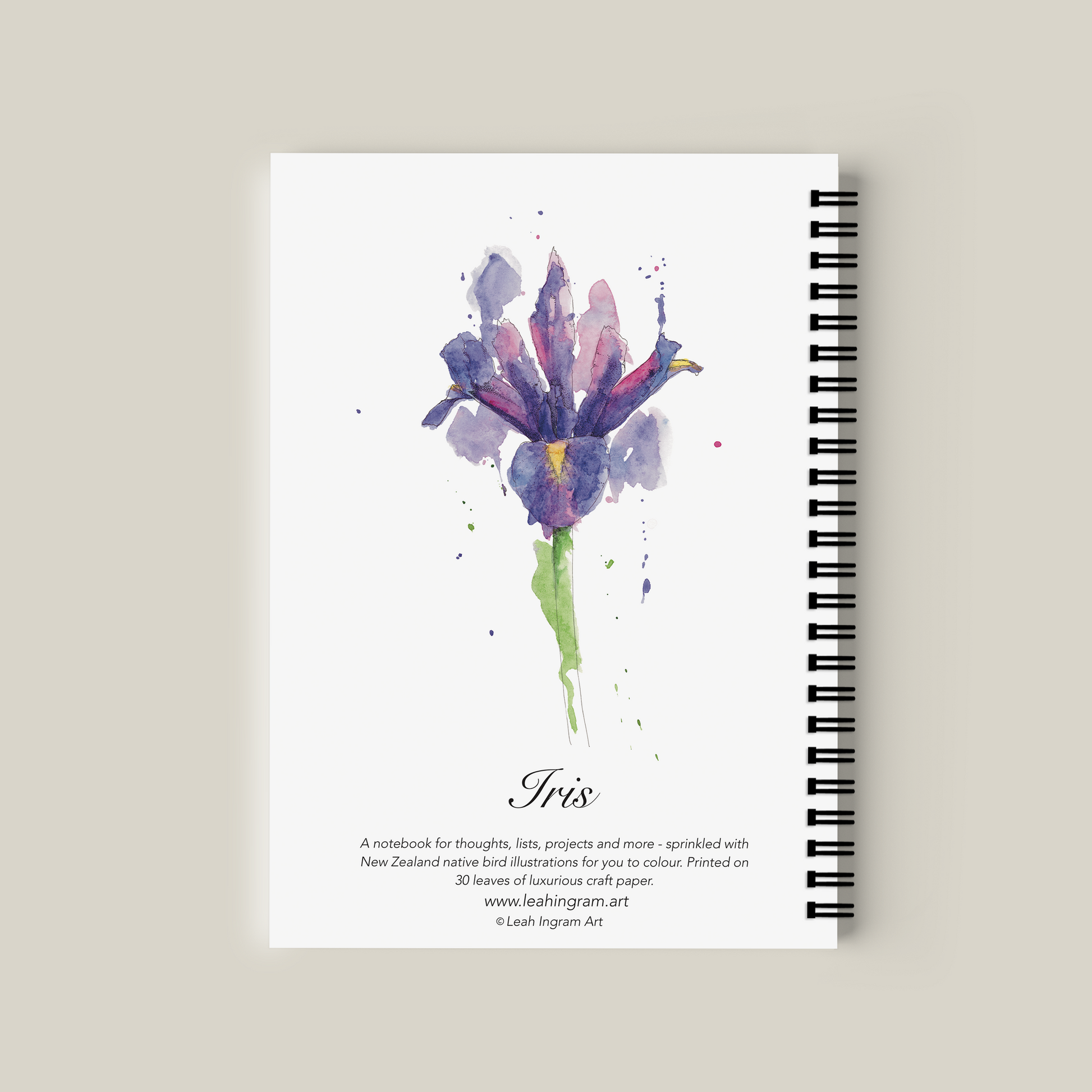 Notebook with watercolor iris design on the cover against a beige background