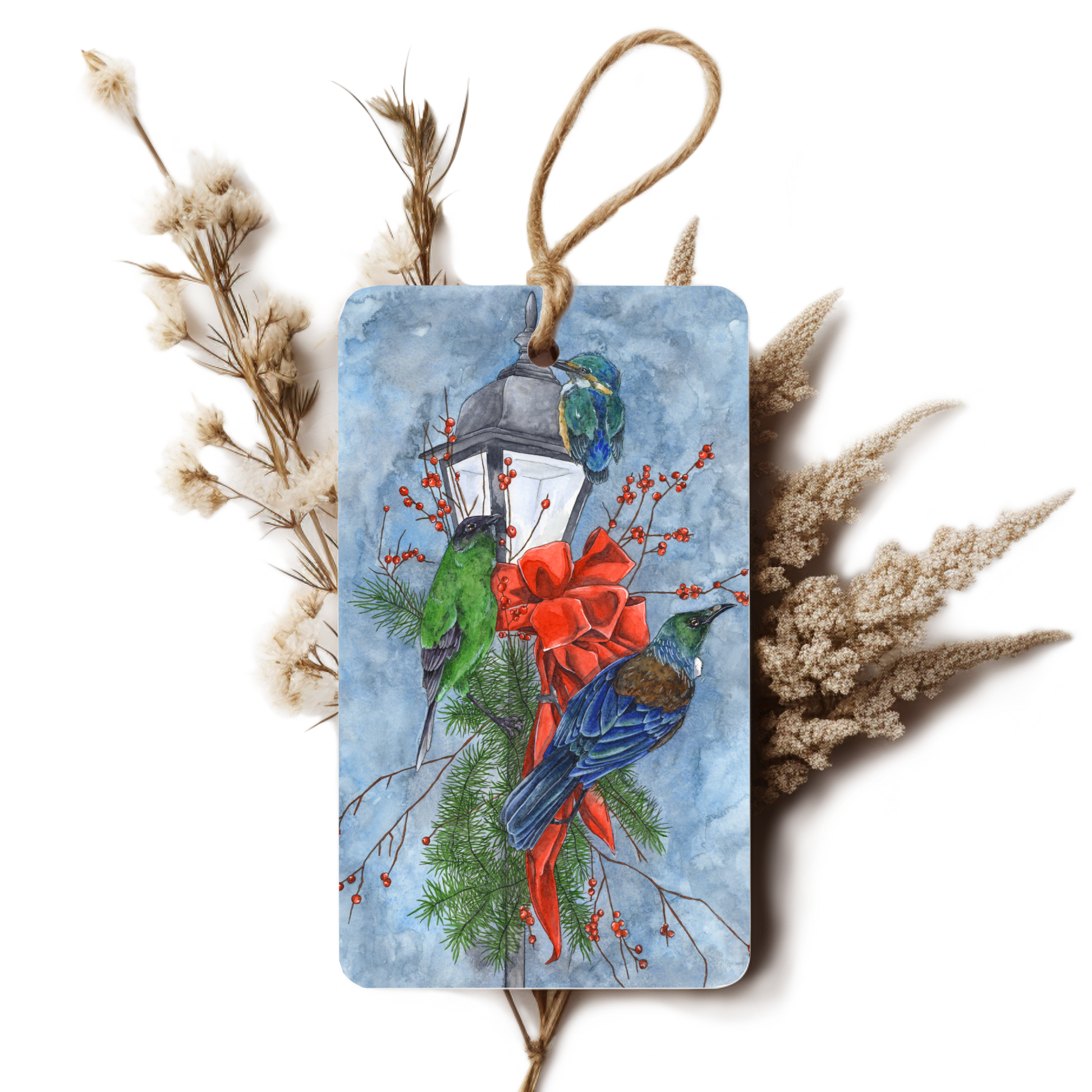 Decorative tag with birds, a lantern, and red ribbon on a white background