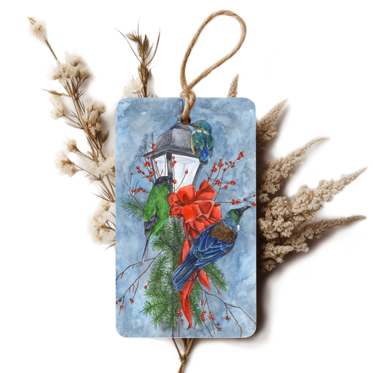Decorative tag with birds, a lantern, and red ribbon on a white background