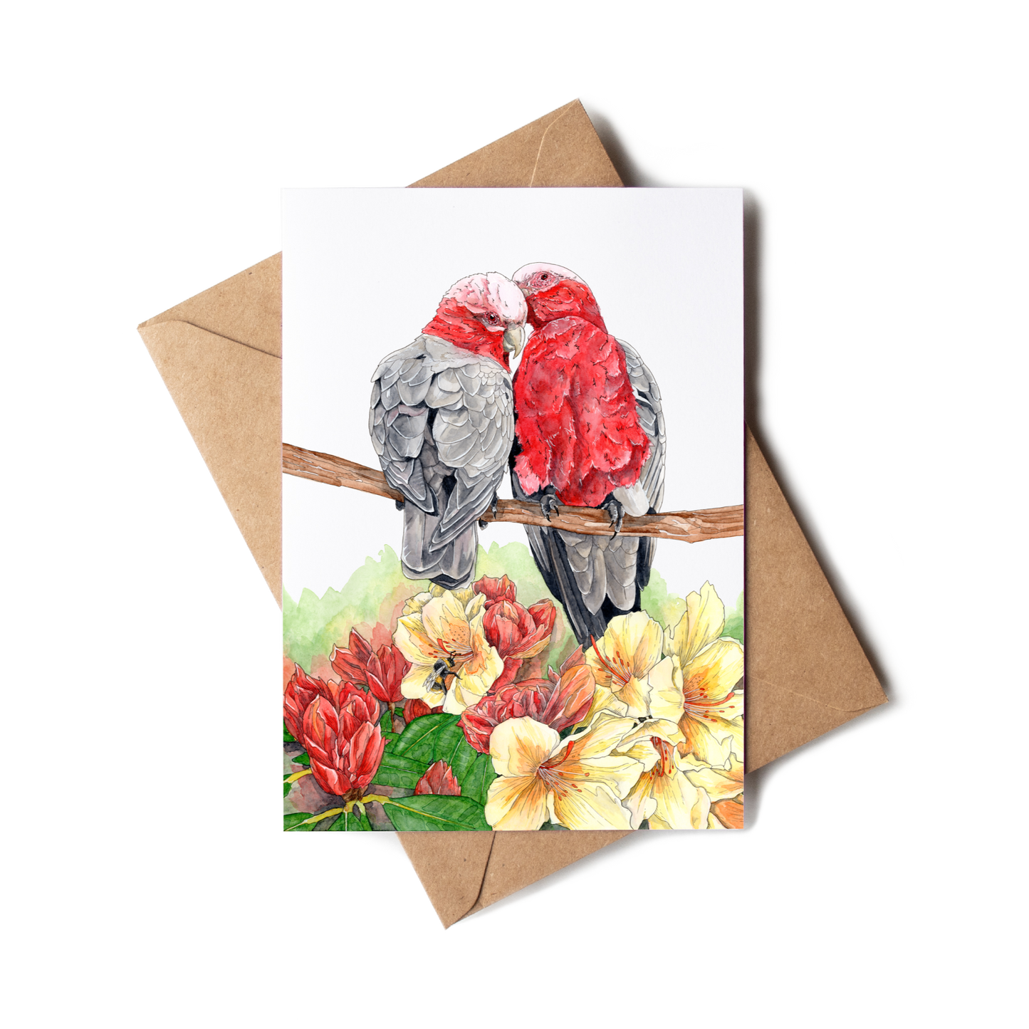 Greeting card with two parrots on a branch and flowers, accompanied by a brown envelope.
