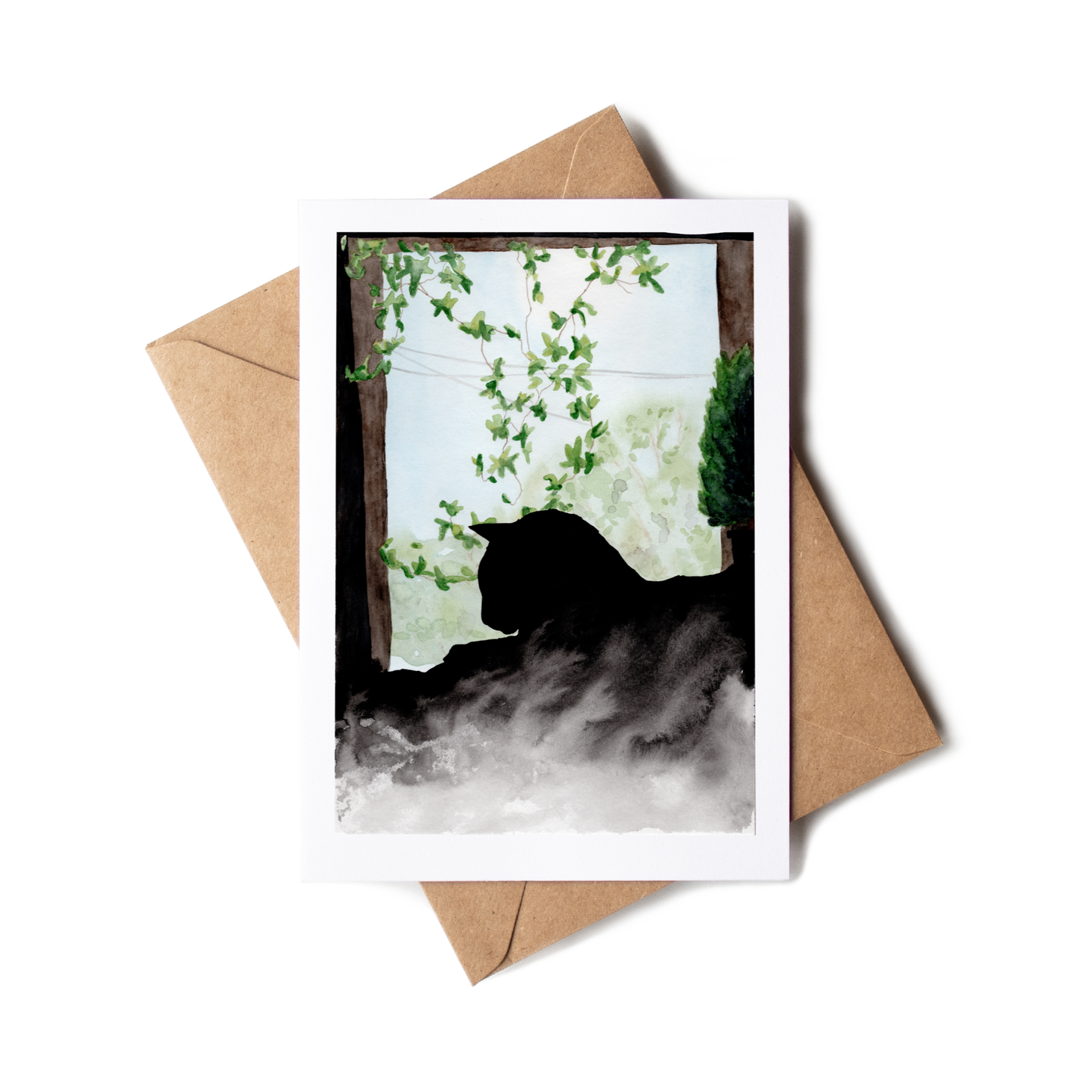 Greeting card with a cat silhouette and floral design, placed on a brown envelope.