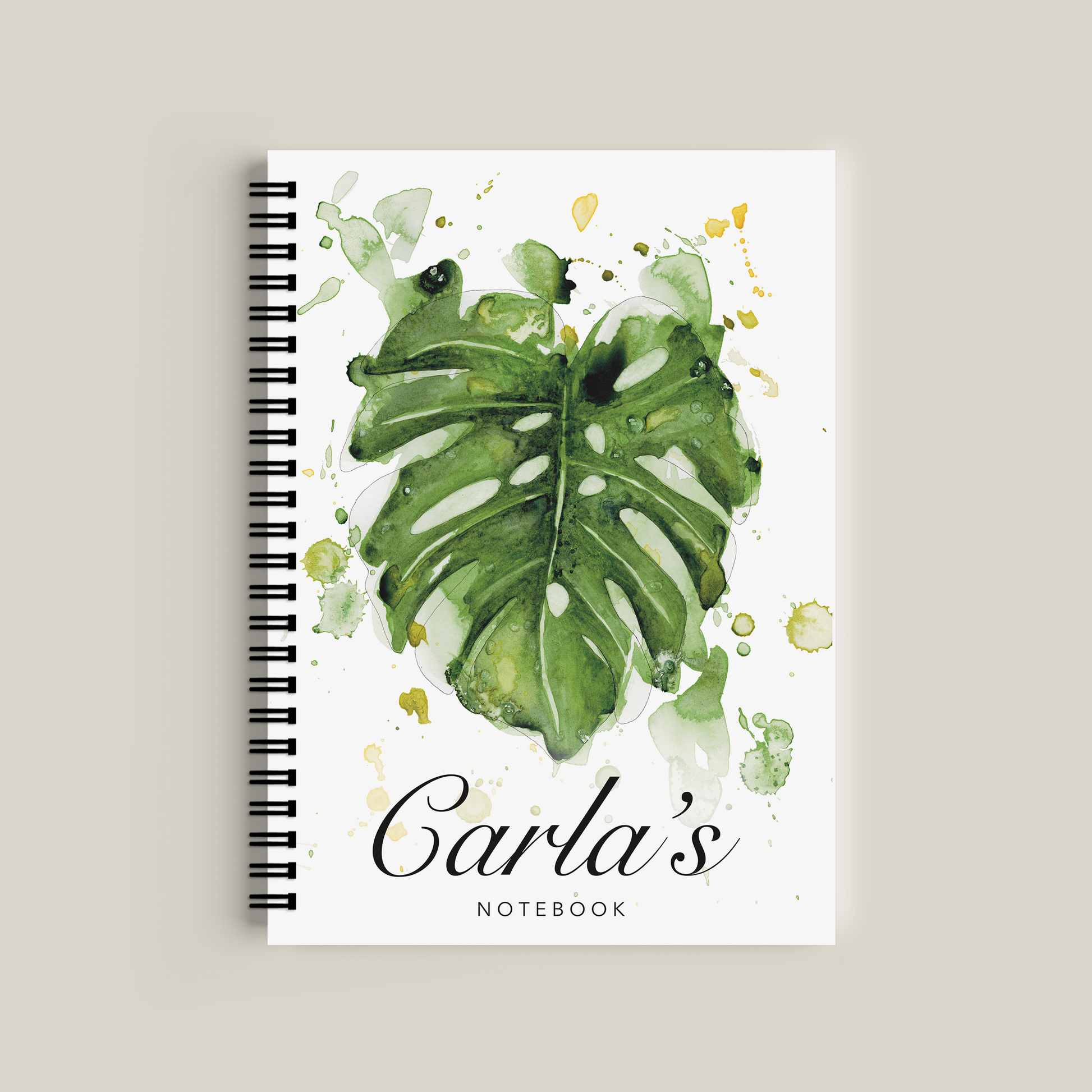 Notebook with green leaf design and 'Carla's Notebook' text on a beige background