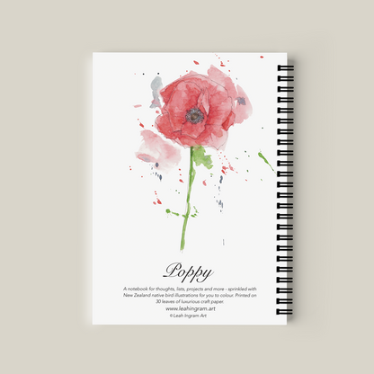 Notebook with watercolor poppy design on the cover against a beige background