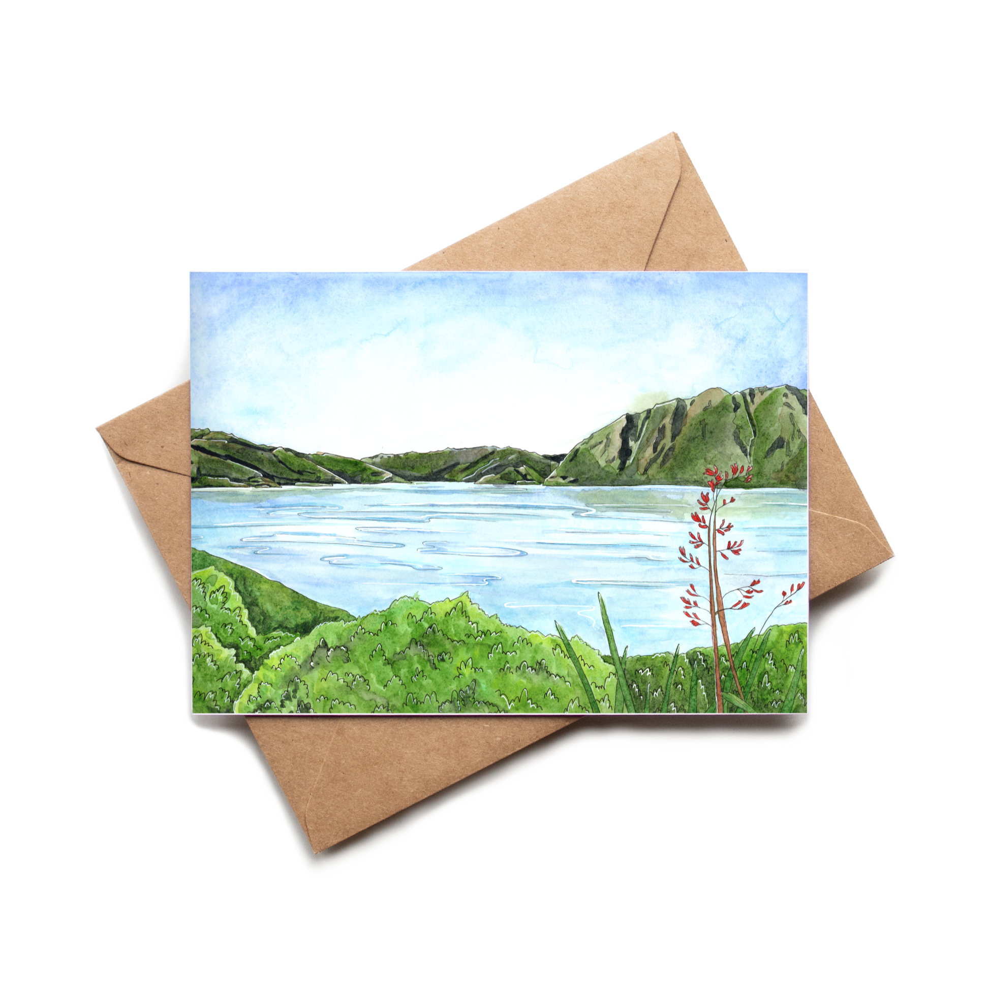 Greeting card with a scenic illustration of a lake and mountains, placed on a brown envelope.
