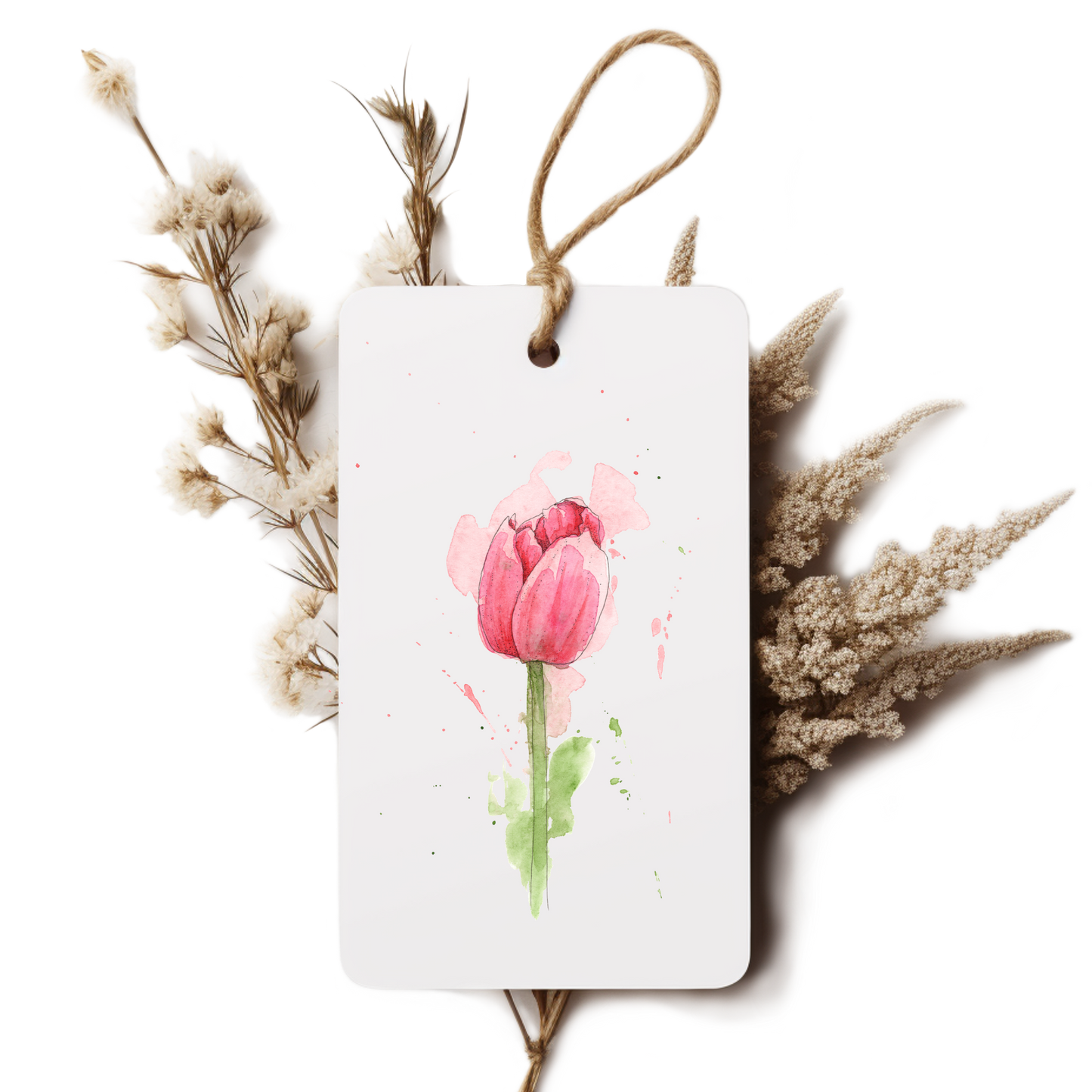 White tag with pink tulip design surrounded by dried flowers on a white background