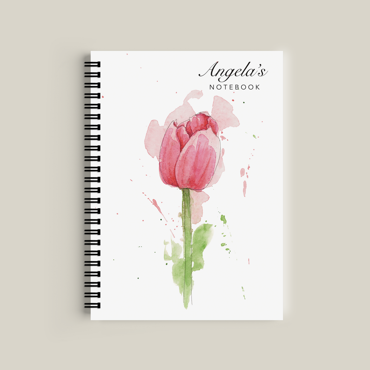 Notebook with a pink tulip design on the cover against a beige background